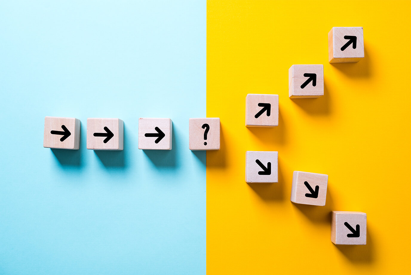Wooden blocks with arrows pointing right end at a question mark block, then continue upward as arrows pointing diagonally up-right, illustrating a decision point that leads to growth.